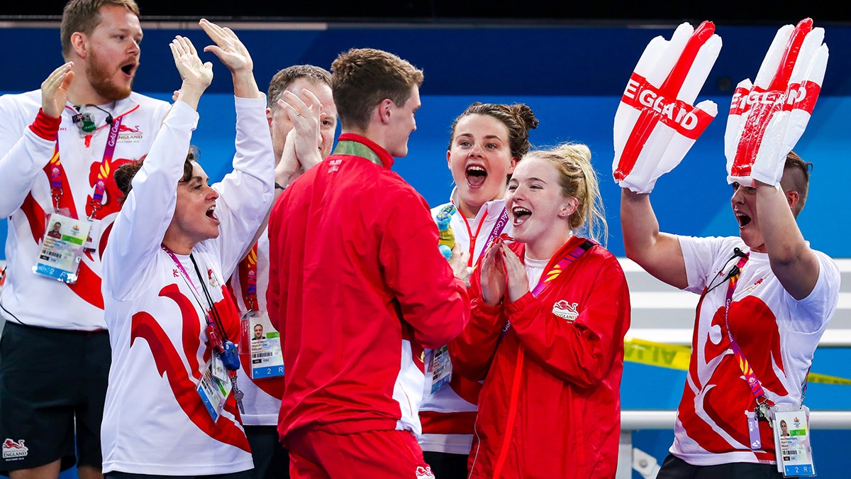 James Wilby celebrates his 200m Breaststroke victory at the 2018 Commonwealth Games with his Team England colleagues